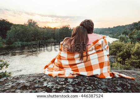 https://image.shutterstock.com/display_pic_with_logo/3120227/446387524/stock-photo-loving-couple-wrapped-in-plaid-sitting-on-mountain-outdoors-on-sunset-rear-view-man-and-woman-446387524.jpg