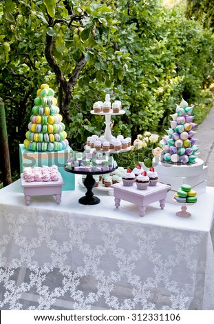 Sweet dessert table or candy bar. Wedding party. Natural light. Macaron and meringue pyramid. Cupcakes and marshmallow.