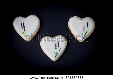 Biscuits vanilla cookies topped with white glaze. Hand drawn with edible coloring lavender flower stems motive. Natural light