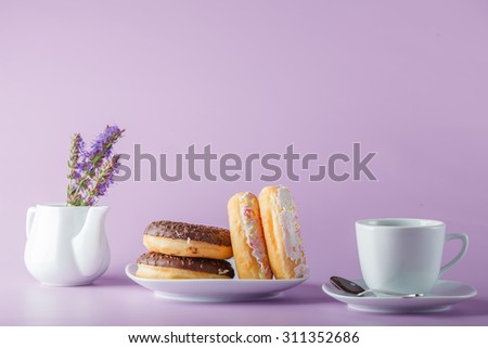 Delicious colorful donuts on dish, plain violet background