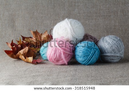 Clews of colored wool yarn with fallen foliage