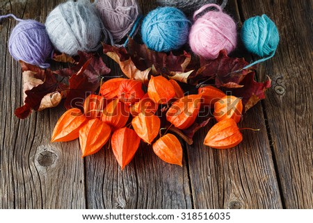 Fall leaves and wool clew  on rustic wooden background. Place for text