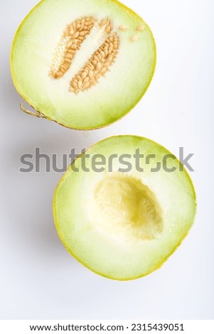 Similar – Image, Stock Photo Halved watermelon with golden forks and flowers at grey concrete kitchen table with champagne glasses