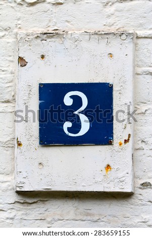 Digit three on the white wall.