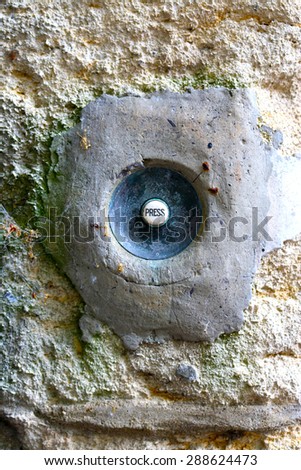 White press button in the old wall.