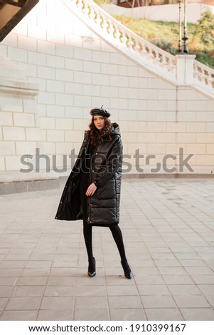 Similar – Image, Stock Photo Woman in black winter jacket and cap looking at black roadster on parking lot