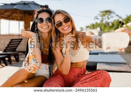 Similar – Image, Stock Photo Laughing women taking selfie on wooden bench at street