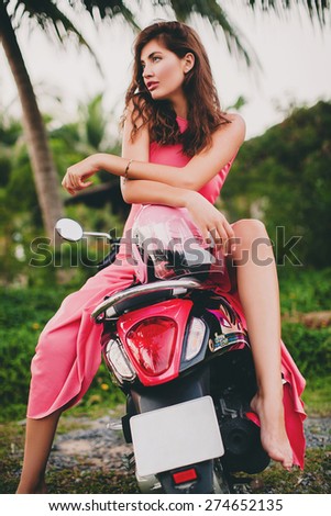 young stylish sexy beautiful woman in pink dress on scooter motorbike, sensual, tropical vacation, island