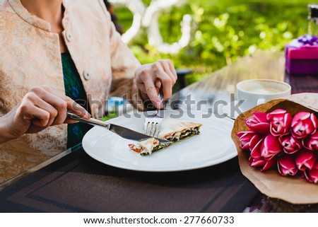 young stylish woman sitting in cafe, eating tasty pie, enjoying healthy food, tulips, happy birthday party, city street, boho outfit, europe vacation, fashion, romantic dinner, hands, close up, detail