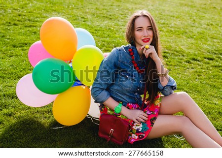 young stylish hipster teen girl happy smiling, park, air balloons birthday party, cool accessories, red lipstick makeup, colorful, sunny, have fun, sitting on grass, denim shirt, braces, sunny