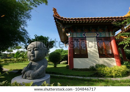 little monk statue in front Chinese traditional building