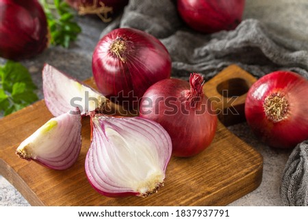 Purple Onions. Fresh whole purple onions and one sliced onion on a stone countertop.