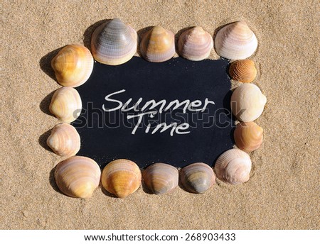 Blackboard on beach sand with the phrase summer time.