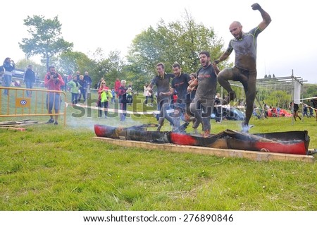 OVIEDO, SPAIN - MAY 9: Storm Race, an extreme obstacle course in May 9, 2015 in Oviedo, Spain. Runners jumping a barrier of fire.
