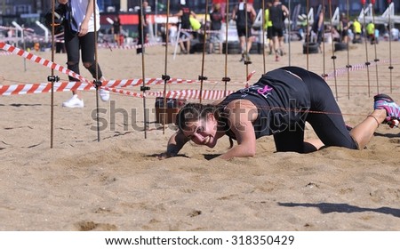 GIJON, SPAIN - SEPTEMBER 19: Storm Race, an extreme obstacle course on September 19, 2015 in Gijon, Spain. Runners crawled under wire.