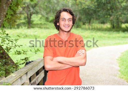 Male model with orange shirt in the woods