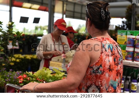 HOUSTON, TEXAS- JULY 2, 2015: Women paying for flowers at Houston garden center