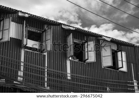 rusted old house wall with wooden window in black and white