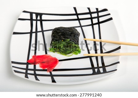Tasty and beautiful composition of Japanese sushi and seaweed Chuka and pink ginger on a square plate