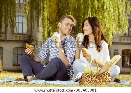 A pair of cute student drinking coffee and eating croissants