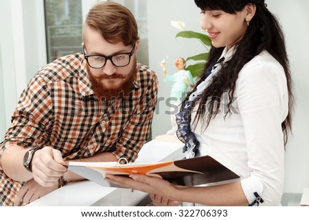 Beautiful girl at the reception shows the customer list of services in office