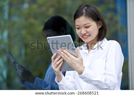 Asian young female executive looking at tablet