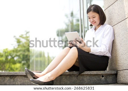Asian young female executive looking at tablet