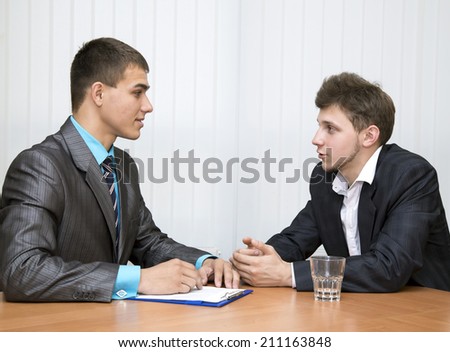 Business negotiations. Salesman and buyer discuss the contract sitting in front of each other at the office room.