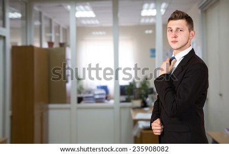 Funny young male businessman inside office background.  One person, dressed according to business dress code, located inside the office interior