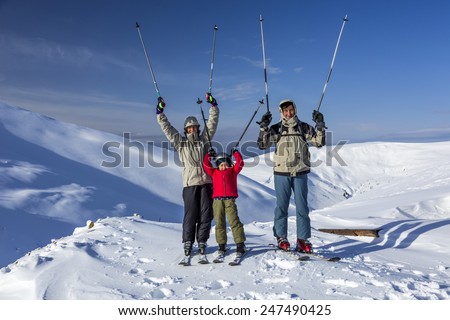 Winter sport family. Family of three people - parents and little daughter - on winter mountains background