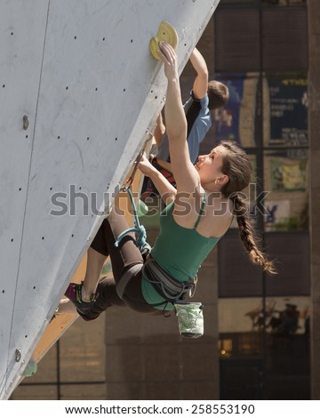 Female climber grabs the hold on the competitions track. National Climbing Championship, Dnepropetrovsk, Ukraine, May 23, 2014, Female Semifinal, Lead climbing