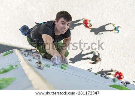 Male athlete makes hard move on climbing wall. National Climbing Championship, Lead climbing qualification round. Dnepropetrovsk, Ukraine, May 22, 2015