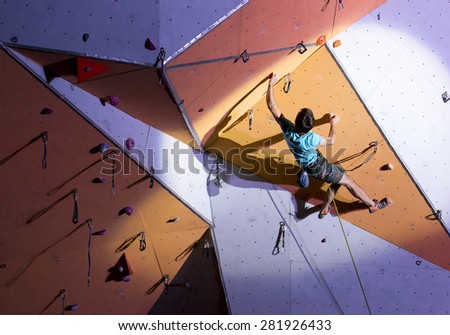 Male athlete makes hard move on climbing wall. National Climbing Championship, Lead climbing finals. Dnepropetrovsk, Ukraine, May 23, 2015