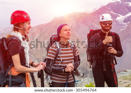 Happy mountain climbers portrait. Three people man and women smiling faces positive expression well gesture high peaks background climbing safety protection gear helmets