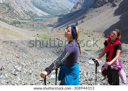 Portrait of Female Hiker.\
Cute Woman Smiling Looking Up Side Point Half Face Optimistic Purposeful Expression Mountain Landscape Blue Sky Background