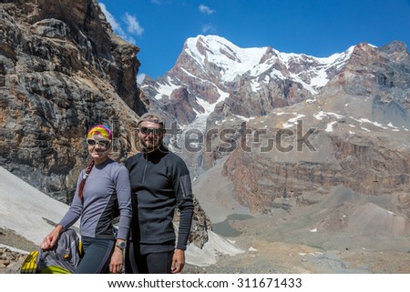 Excited Travelers.\
Young Man and Woman Traveling Outdoor Expressing Fun and Pleasure Casual Sporty Style Clothing Majestic Himalaya Mountain Landscape on Background