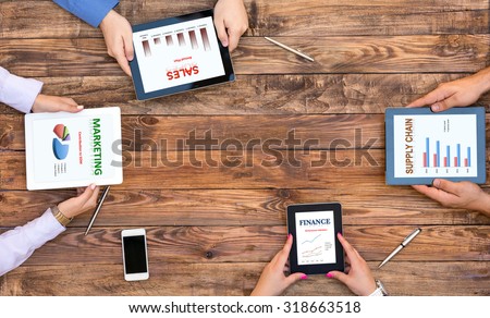 Corporate Functions Business Meeting Top View of Wooden Desk and Hands of Young Business People Working with Electronic Gadgets Specific Charts on Every Screen Dedicated to Particular Company Function