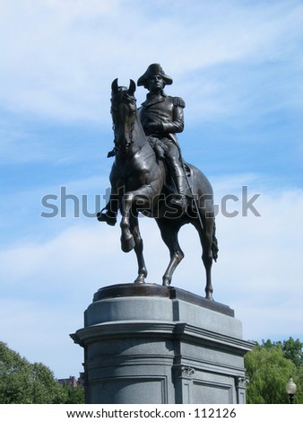 Stature of George Washington at entrance to Boston Public Garden, bright blue sky with wispy clouds