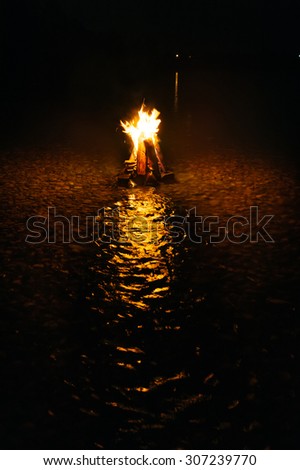 magic fire in the mountain river on the rocks at night
