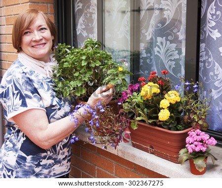 Happy woman transplant flowers