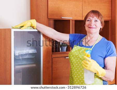 Mature woman rubs dust and cleans the house