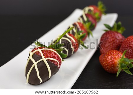 red chocolate dipped in dark chocolate decorated with white chocolate drizzle