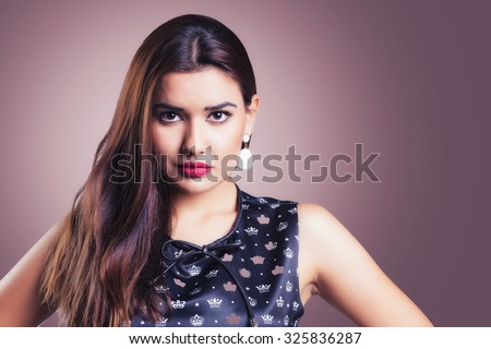 Nice dark Brown haired beautiful girl, with a masculine pose, wearing dress in front of a pink background