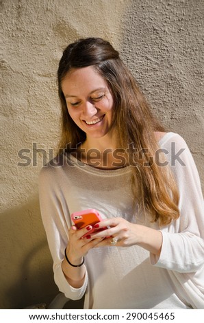Young female looking at her cell phone, reading a text message - angled photo