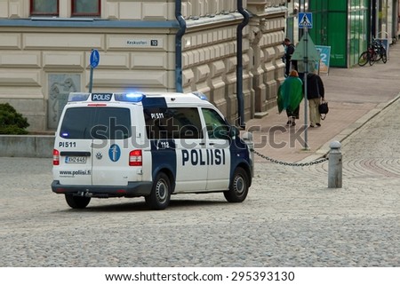 TAMPERE, FINLAND - JUNE 10: Police car flashing lights switched on on June 2015 in Tampere/Finland. In the background an unidentified man.