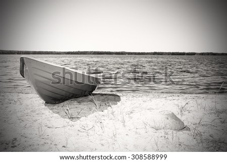Rowing boat pulled to the beach in Finland. In the background is the lake. Image includes a effect.