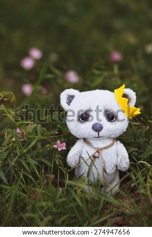 Blue artist Teddy bear in flower garden