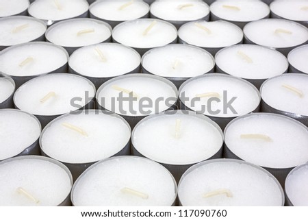 Several rows of unlit tea light candles.