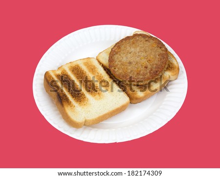 A cooked veggie burger on white bread toast atop a paper plate against a red background.