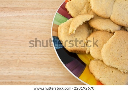 A plate of homemade sugar cookies on a wood table top.